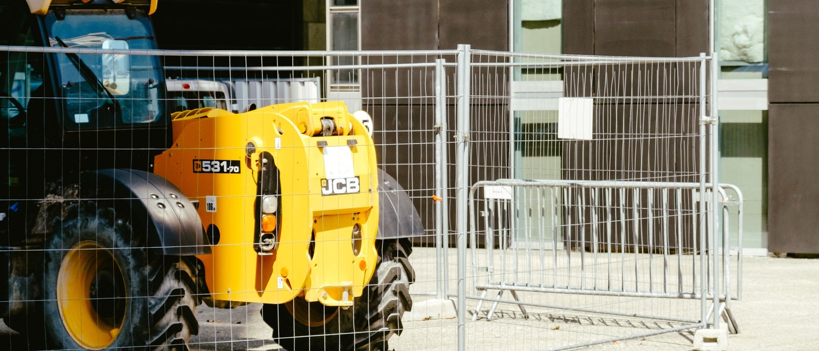 Clôture de chantier grillagée autour d'un engin de levage, sur une emprise urbaine